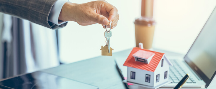 A man hands over keys to a house