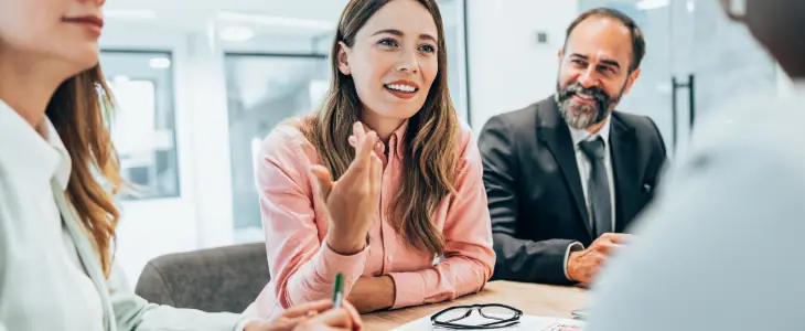 Woman talks business at a table with coworkers