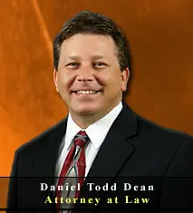 Portrait of Daniel Todd Dean, an attorney, against a warm-toned background.