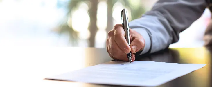 professional man writing on a paper on a table estate planning