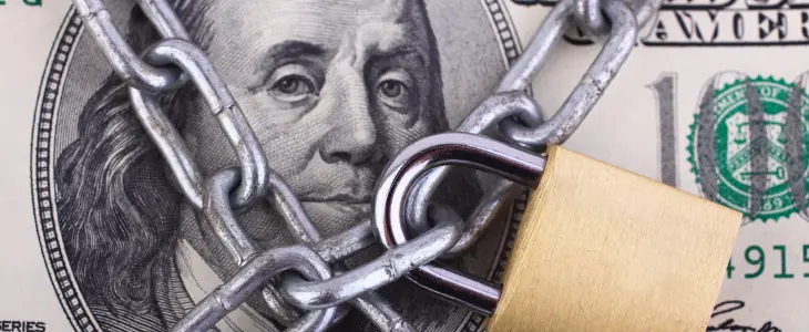A one hundred dollar bill chained with a lock